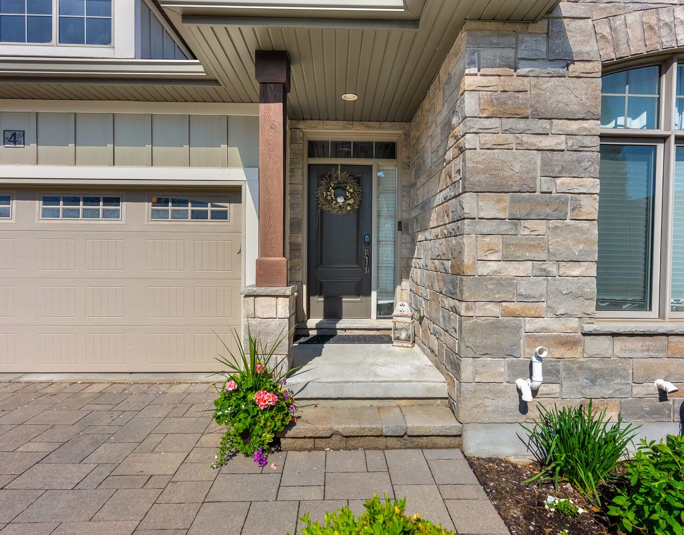 Exterior of home with a black front door and a planter at front steps